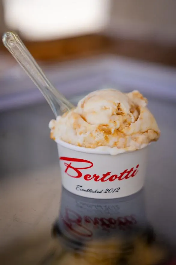 A freshly scooped Bertotti gelato cup with the signature red script logo